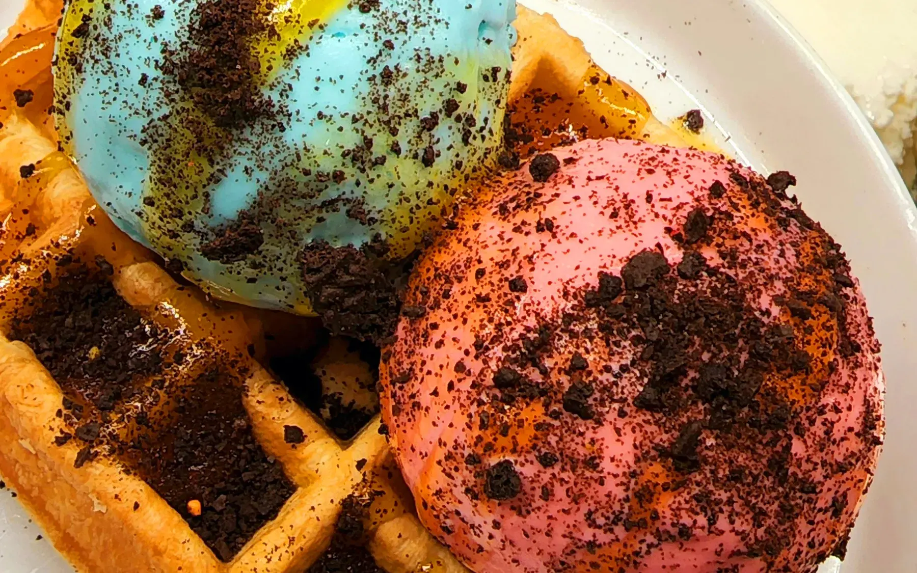 Dua scoop gelato di atas waffle dengan remah cookies